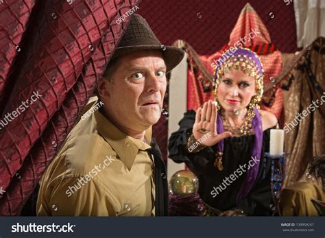 scared businessman and fortune teller displaying the evil eye stock