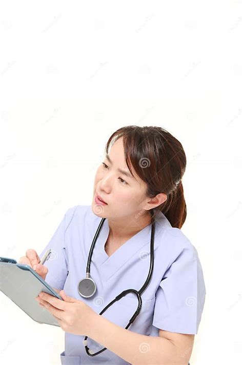 Japanese Female Doctor With Clinical Record Talks To Her Patient Stock