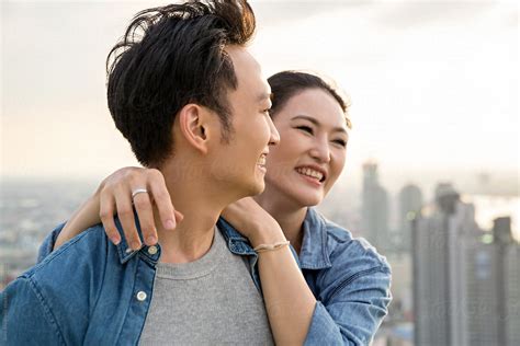 portrait of a happy asian couple laughing del colaborador de stocksy