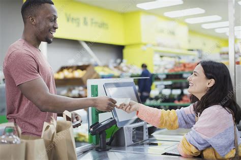 cashier giving receipt  customer  supermarket checkout stock