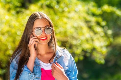 Beautiful Emotional Young Woman In Sunglasses Talking On The Phone