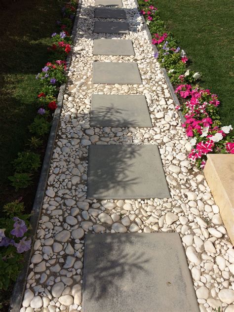 cement block tiles bordered  white pebbles   simple pathway