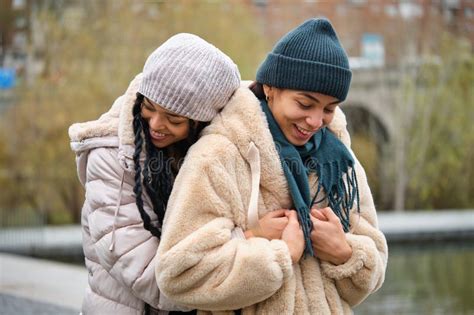 dominican lesbian couple hugging with affection and love at street in