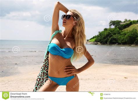 Woman With Blond Hair In Bikini And Sunglasses Relaxing On Beach Stock