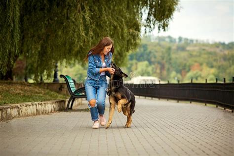 Una Chica Joven Está Caminando Con Un Perro En El Parque Foto De