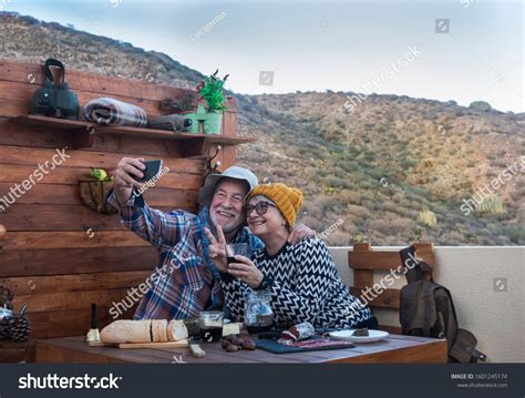 two smiling senior people looking at cellphone for a