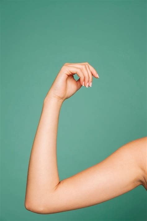 A Womans Arm Showing Her Muscles And Holding It In The Air With One Hand