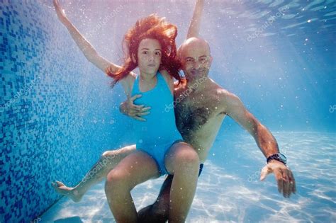 Father And Daughter Having Fun Underwater In Swimming Pool
