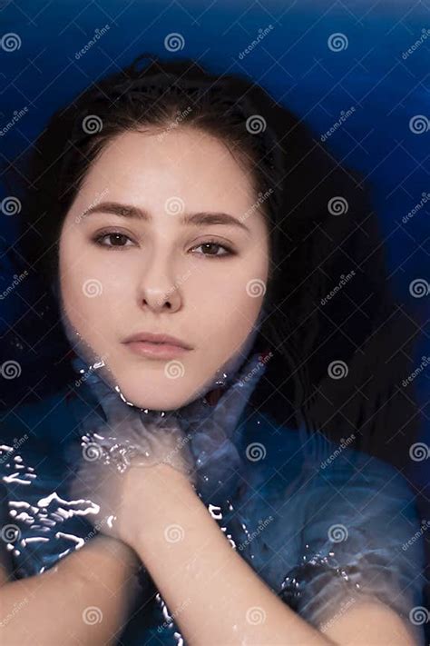 Portrait Of Attractive Brunette Woman Topless In Blue Liquid In