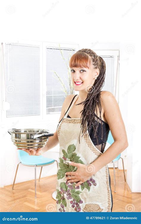Young Pregnant Housewife Wearing Apron In The Kitchen Smiling Stock