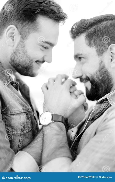 Black And White Portrait Of Young Gays Holding Hands And Wearing Jeans