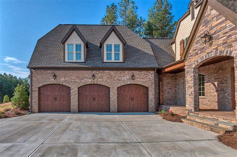 car garage arched garage opening courtyard style home brick  stone house styles