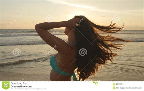 Attractive Girl With Long Hair Posing On The Ocean Shore At Sunrise