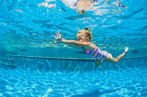 funny portrait  child learn swimming diving  blue pool  fun
