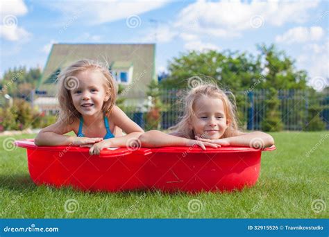 Two Little Sisters Frolicing And Splashing In Royalty Free Stock Image