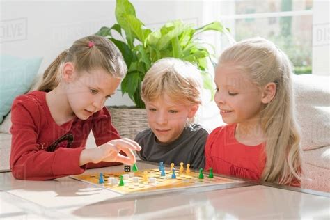 children playing  board game stock photo dissolve