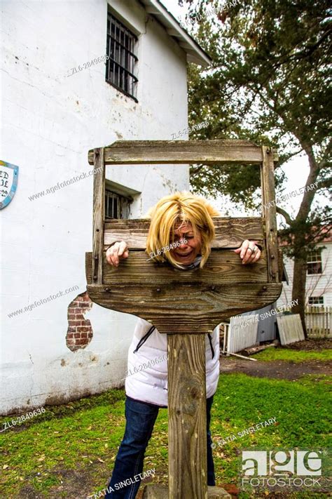 Blond Caucasian Woman Getting In The Guillotine And Is Pretending