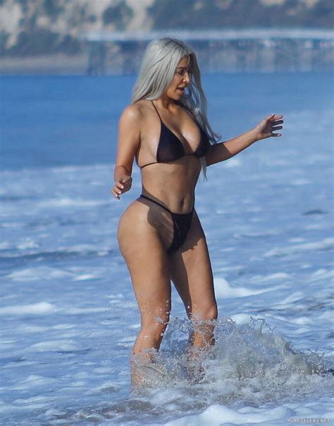 kim kardashian sunbathing in tihy bikini on the beach in malibu