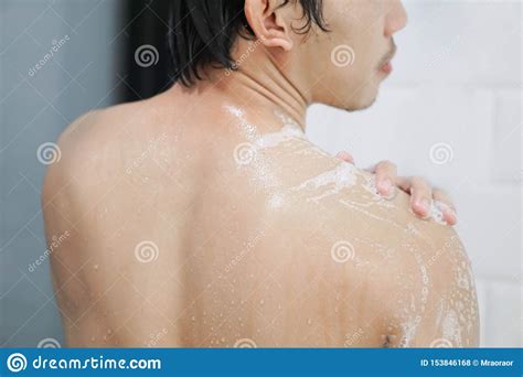 closeup handsome asian man taking a shower in the bathroom