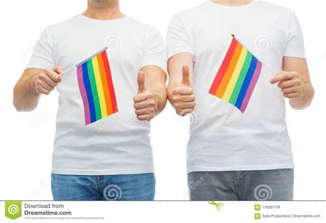 male couple with gay pride flags showing thumbs up stock image image