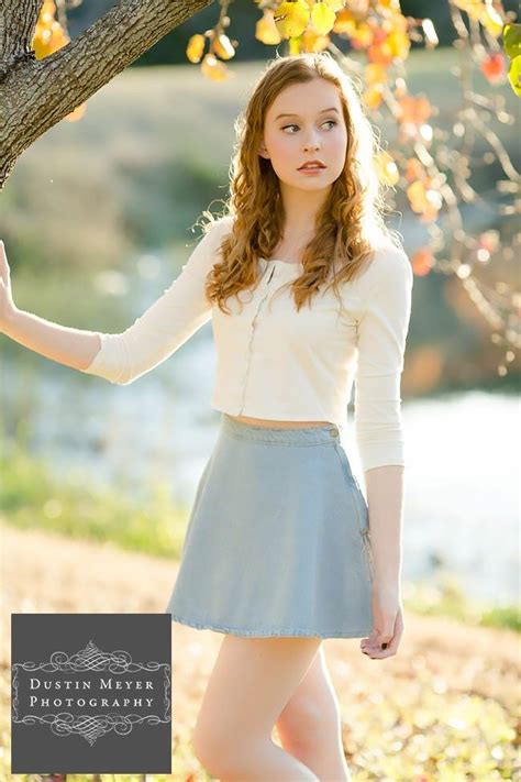 gorgeous female senior portraits blue skirt white button long sleeve shirt blonde curly hair