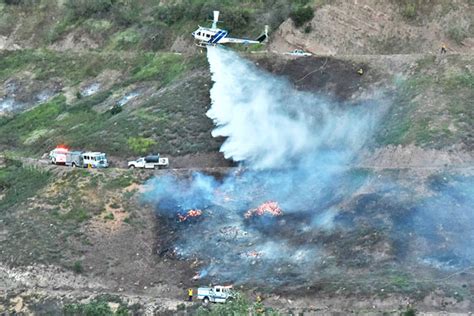 a santa barbara county helicopter drops water on a vegetation fire that broke out tuesday