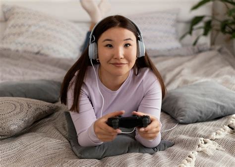 Free Photo Girl Playing Videogame In Bed Full Shot