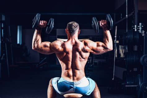 premium photo muscular man training his shoulders with