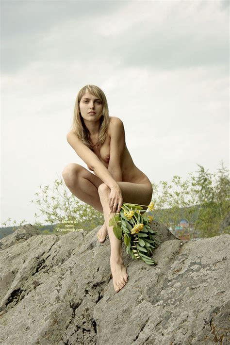 long legged nude blond girl squatting on a rock july 2007 voyeur