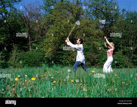 couple outdoors  butterfly nets catching butterflies  spring stock photo alamy