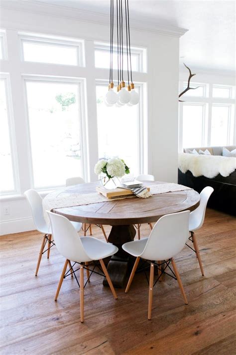 rustic  wood table surrounded  white eames dining chairs