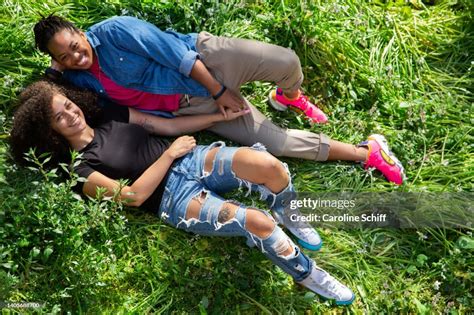 A Beautiful Lesbian Couple Laying In The Grass Laughing High Res Stock