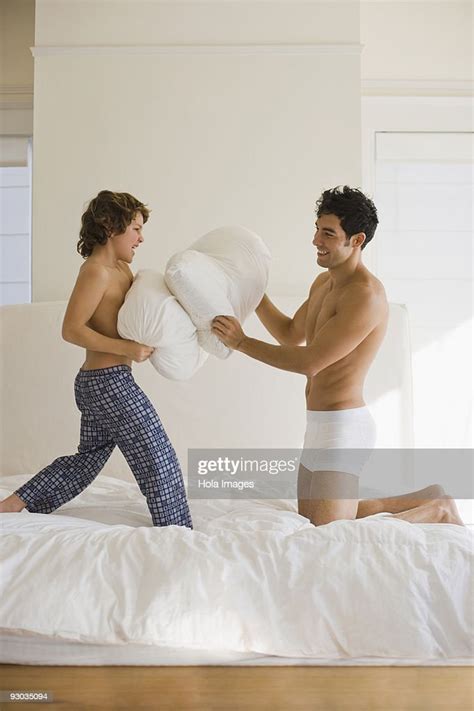 man and his son having a pillow fight in the bedroom photo getty images