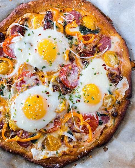 breakfast pizza topped with eggs sausage cheese bacon and yellow