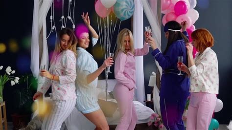 Group Of Dancing Girls At A Pajama Party With Glasses Of Champagne