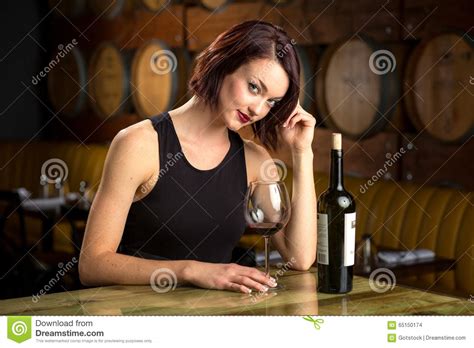 single female alone at restaurant bar drinking wine alone