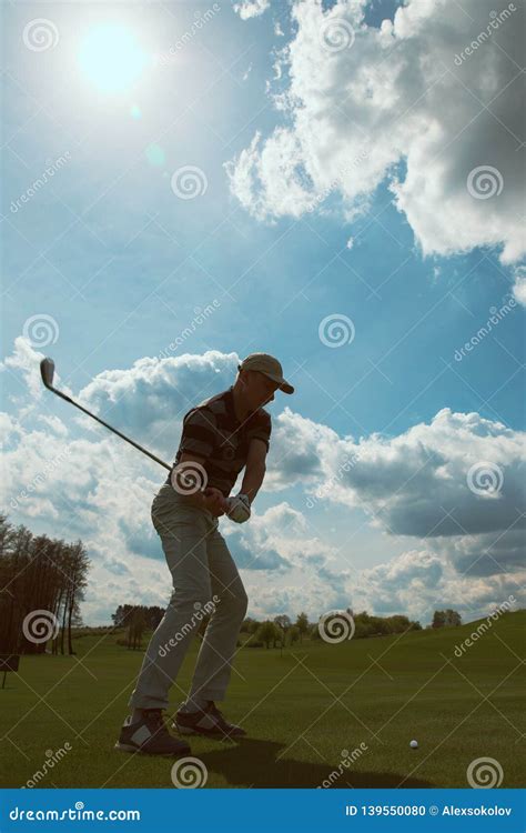 man playing golf  hitting  golf ball  sunny day stock photo