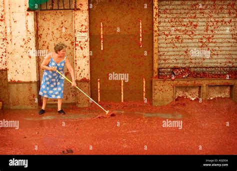 An Old Woman Cleans Up After The Tomatina Tomato Festival In Buñol