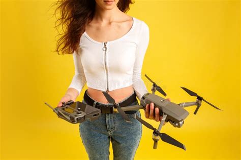 teen girl launches aerial drone quadcopter isolated   yellow background aerial photography