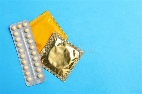 condoms and birth control pills on pink background safe sex stock