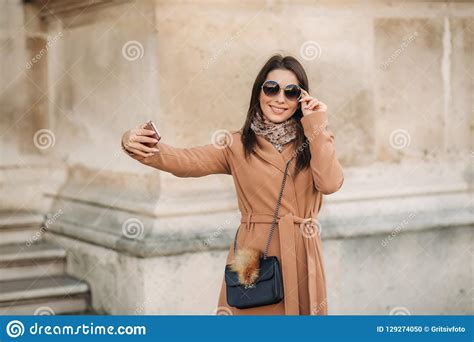 beautiful girl in sunglasses make photo on smartphone