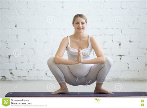 zwangere jonge vrouw die prenatale yoga doen de slinger malasana stelt stock foto image
