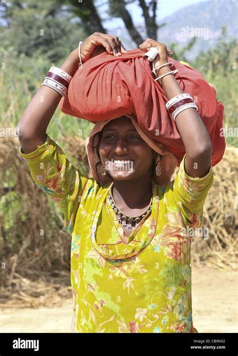 colourful traditional village woman carrying her belongings on her head