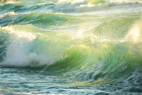 rough colored ocean wave breaking  sunrise shot stock photo