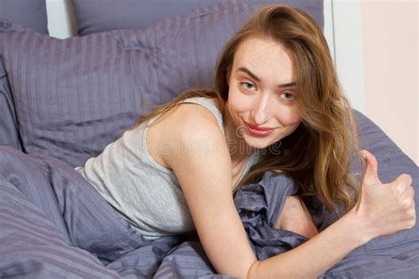 Portrait Of A Beautiful Smile Girl With Closed Eyes On The Bed After