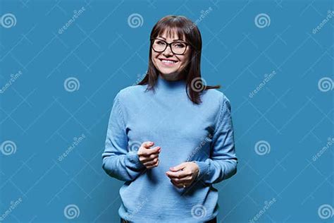 Portrait Of Positive Mature Woman With Glasses On Blue Background Stock