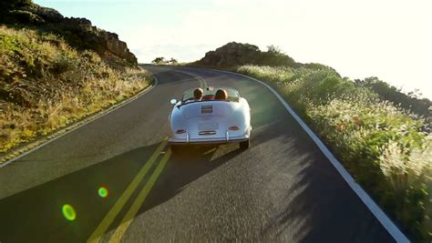 happy couple driving classic convertible car into sunset on country road romantic freedom