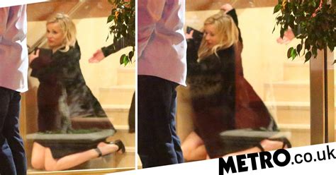 reese witherspoon takes a tumble on way out of jennifer aniston s 50th