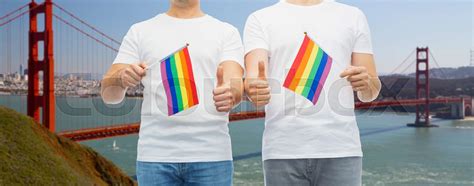 male couple with gay pride flags showing thumbs up stock image