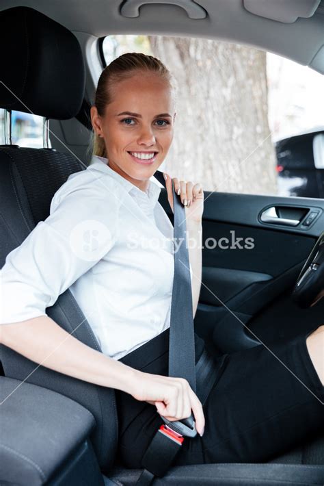 Smiling Businesswoman In Car Fastening Seat Belt Royalty Free Stock